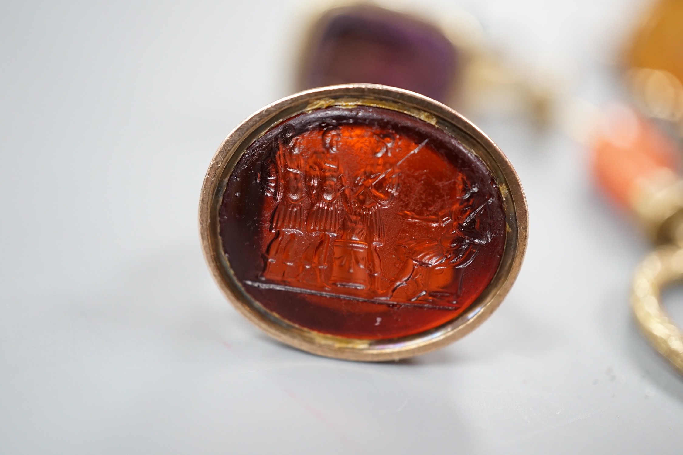 Six assorted late 19th/early 20th century gem set fob seals, including yellow metal overlaid with red intaglio stone carved with Roman soldiers, two 9ct gold, carnelian and bloodstone and a carnelian carved with family c